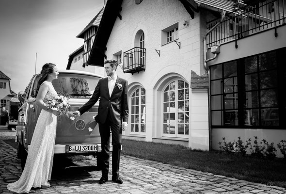 Braut und Bräutigam kommen im VW Bus zus Hochzeitsfeier