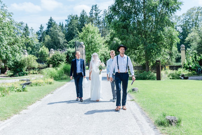 Gemeinsamer Einzug von Braut und Bräutigam zur freien Trauung im Obstgarten von Gut Sonnhausen | Strauß & Fliege