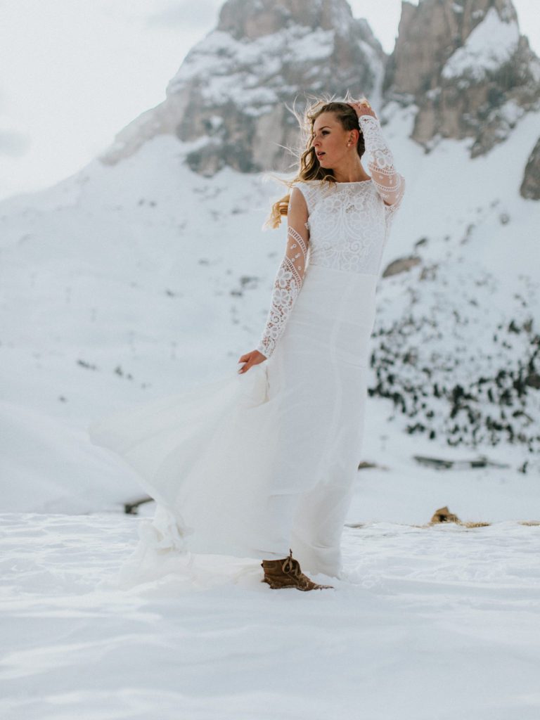 Braut im Brautkleid in den verschneiten Bergen