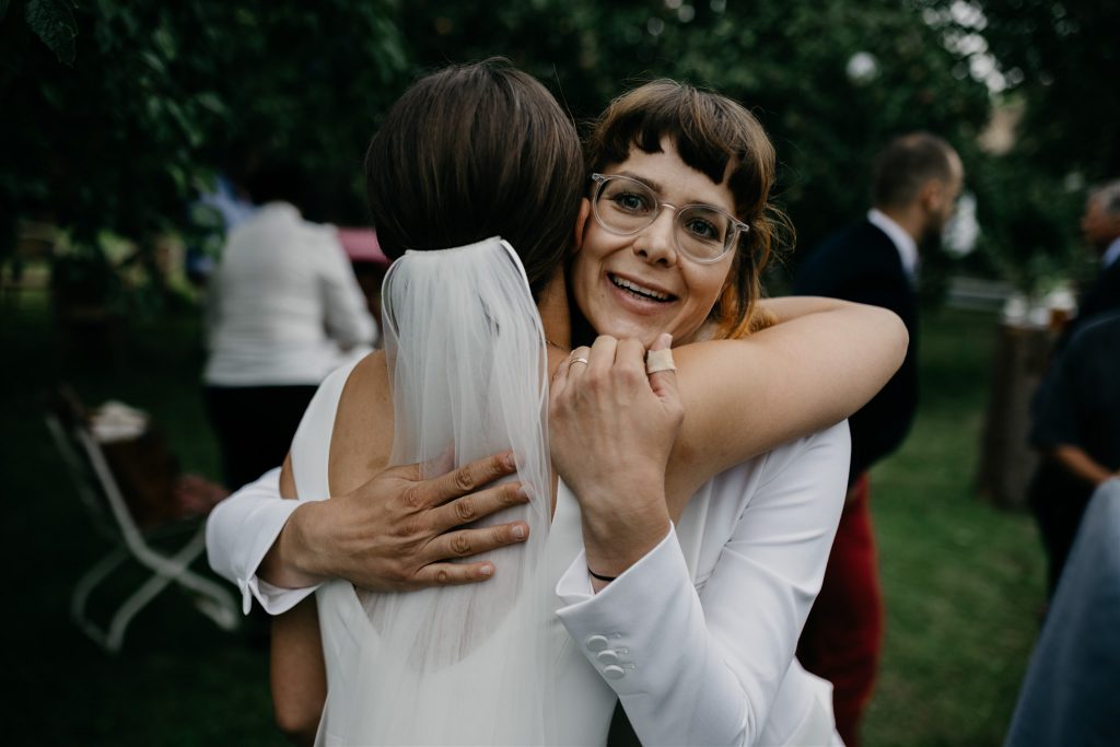 Glückliche Braut umarmt Hochzeitsrednerin vor Freude | Strauß & Fliege