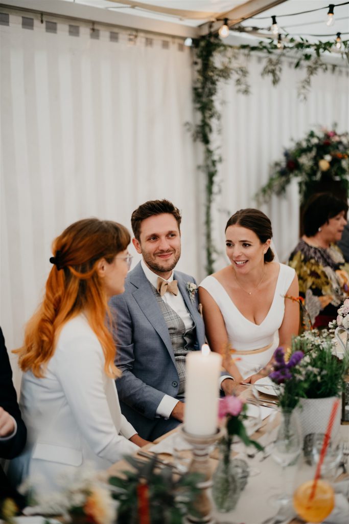 Brautpaar am Hochzeitstisch mit Gast  | Strauß & Fliege