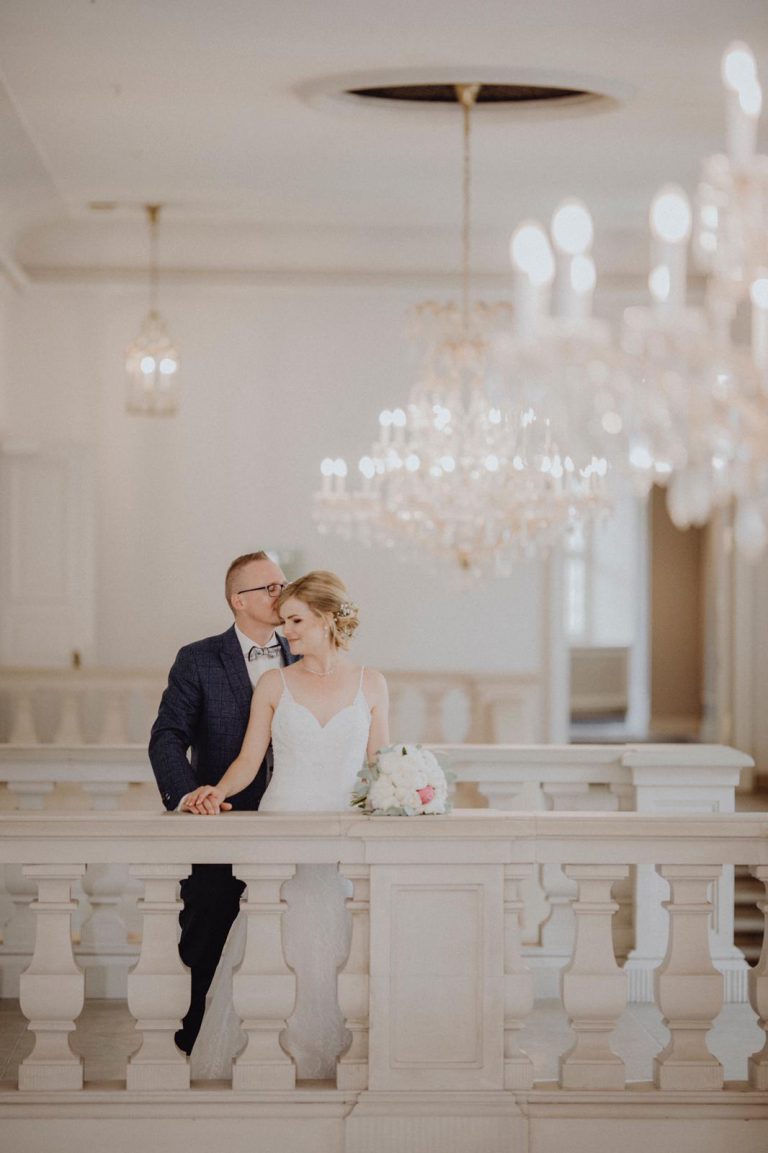 Brautpaar im eleganten Schloss mit Kronleuchtern