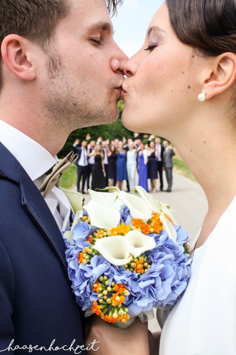 Kreatives Foto mit Brautpaar und Hochzeitsgesellschaft | Strauß & Fliege