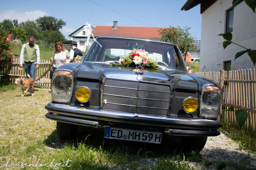 Oldtimer Hochzeitsauto geschmückt für die Feier | Strauß & Fliege